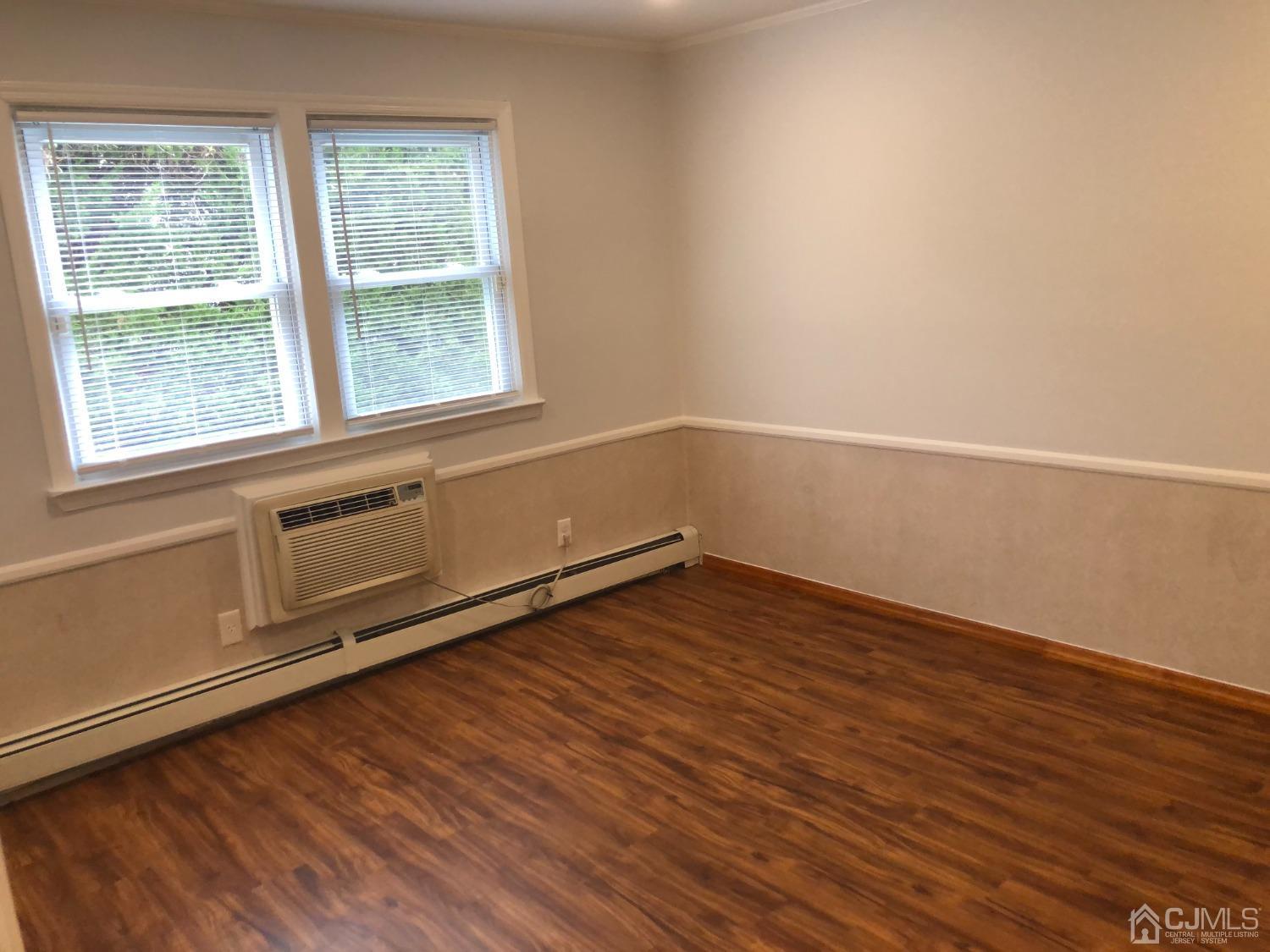 420 Cross Road, Unit B11 Matawan, NJ 07747 - Photo 7 of 9 an empty room with wooden floor and windows