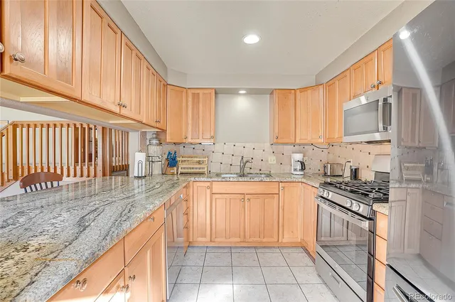 a kitchen with stainless steel appliances granite countertop a sink stove and cabinets