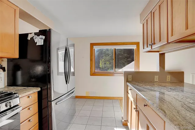 a kitchen with stainless steel appliances granite countertop a refrigerator and a sink