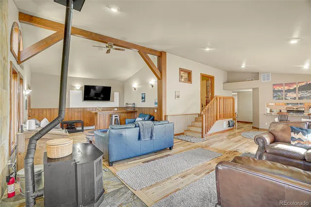 a living room with furniture a flat screen tv and a floor to ceiling window
