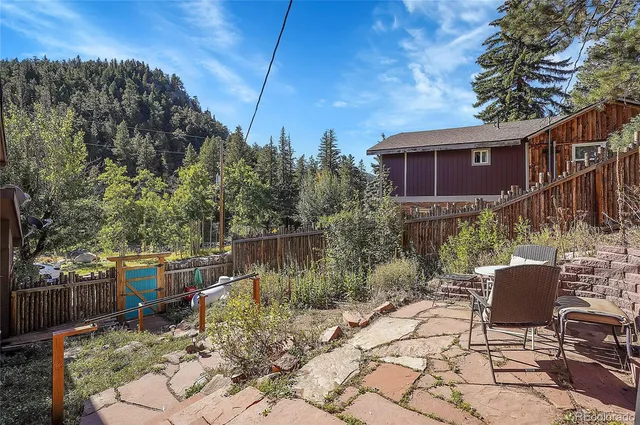 a view of a chairs and table in backyard of house