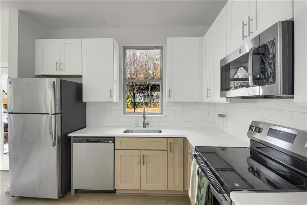 1070 Dill Avenue Southwest, Unit 201 Atlanta, GA 30310 - Photo 6 of 17 a kitchen with stainless steel appliances white cabinets and a refrigerator