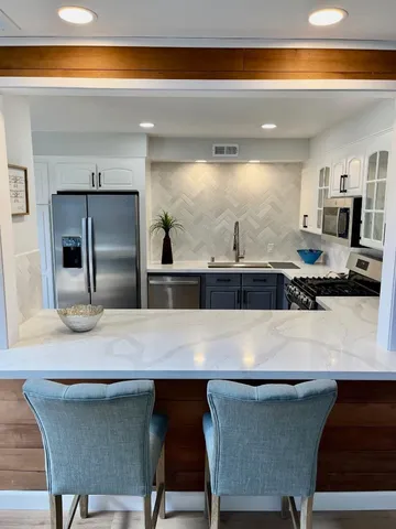 a kitchen with granite countertop a table chairs sink and stove