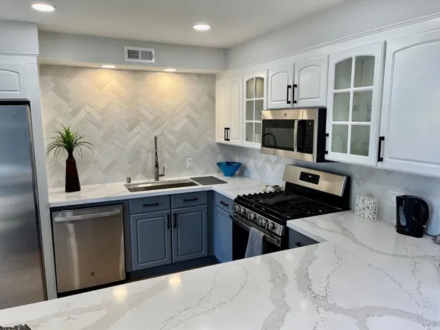 a kitchen with stainless steel appliances a stove a sink and a microwave