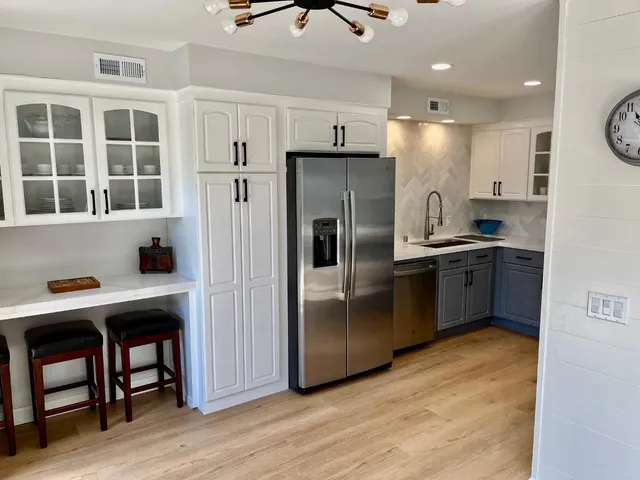 a kitchen with stainless steel appliances granite countertop a refrigerator and a sink