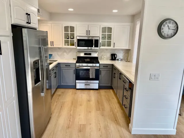 a kitchen with stainless steel appliances a stove top oven a sink and a refrigerator