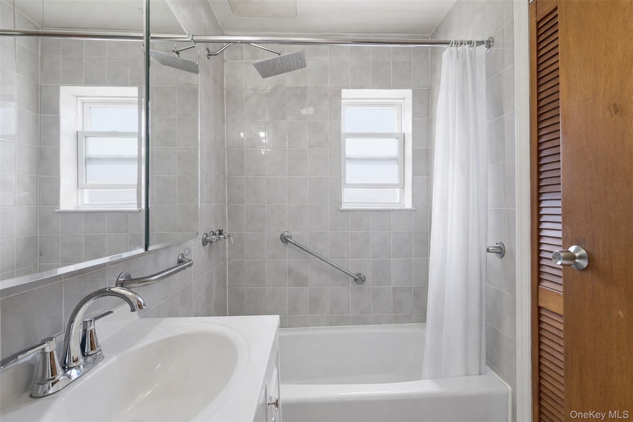1677 Unionport Road Bronx, NY 10460 - Photo 12 of 33 Full bathroom featuring vanity, a closet, shower / bath combo, and tile walls