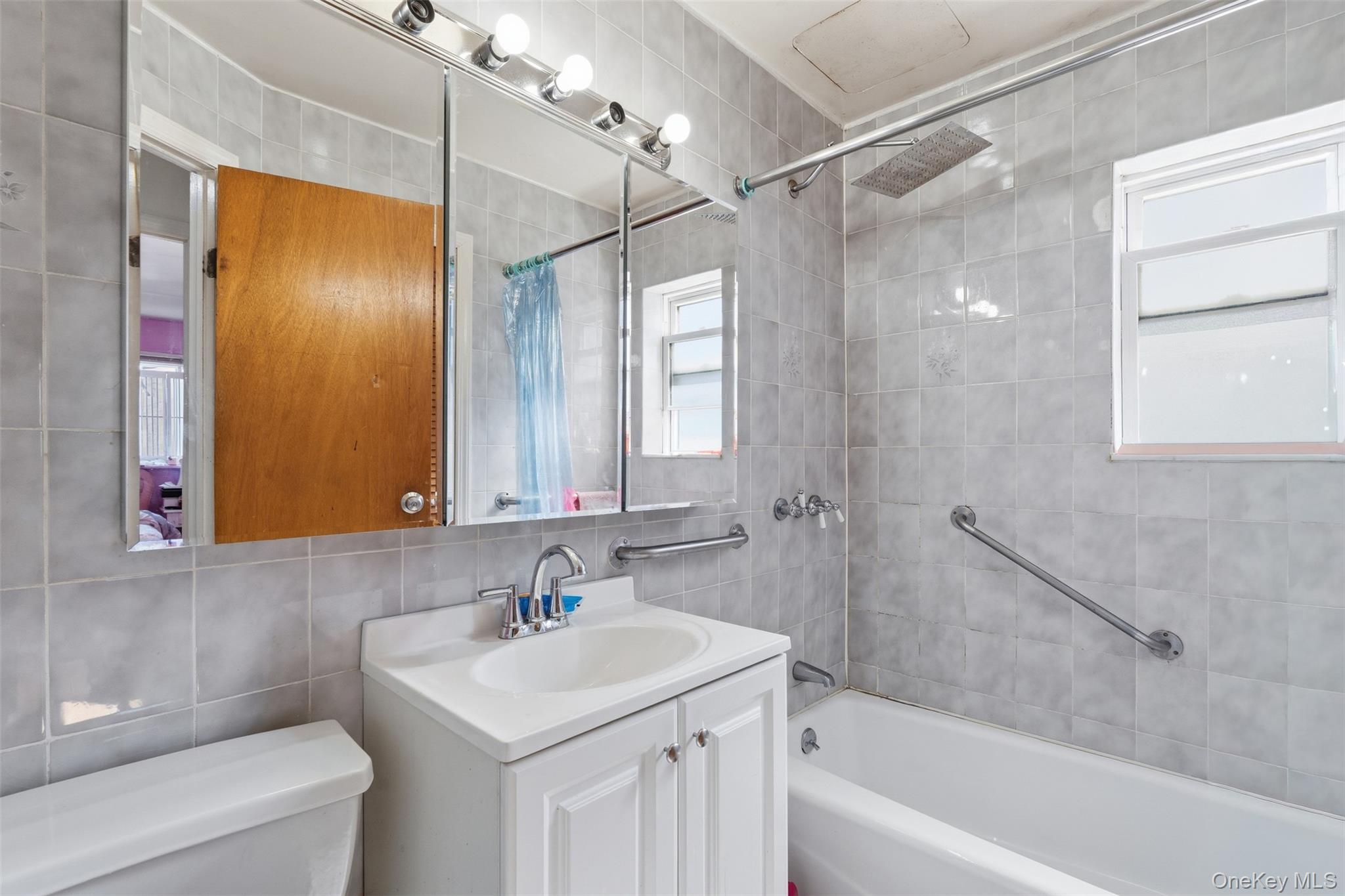 1677 Unionport Road Bronx, NY 10460 - Photo 26 of 33 Bathroom featuring vanity, shower / tub combo with curtain, tile walls, and backsplash