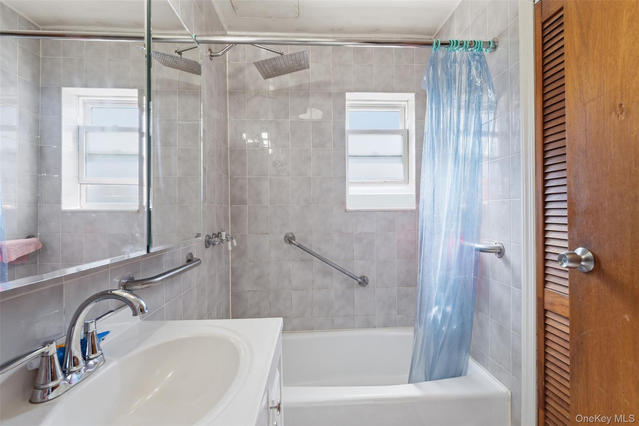1677 Unionport Road Bronx, NY 10460 - Photo 27 of 33 Bathroom with a closet, shower / tub combo with curtain, vanity, and tile walls