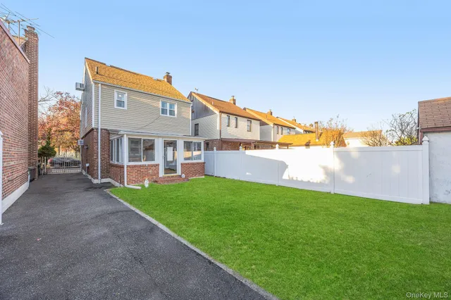 a view of a house with backyard and a tree