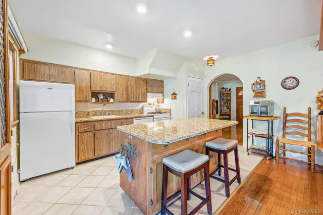 a kitchen with stainless steel appliances granite countertop a table chairs sink and cabinets