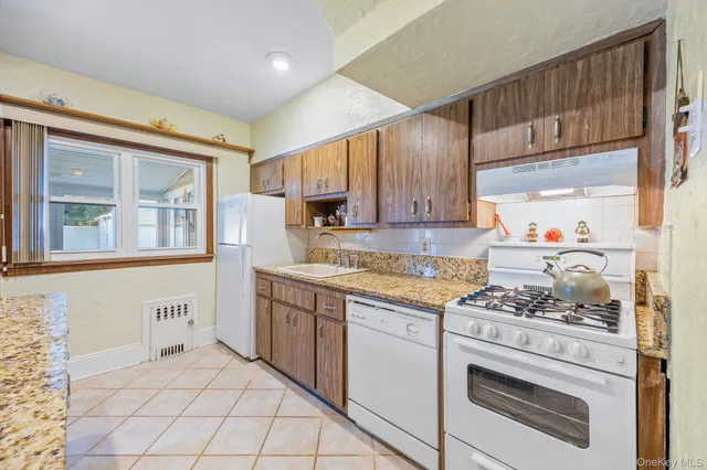 a kitchen with white cabinets and appliances