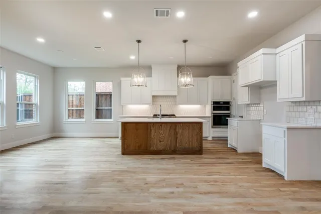 a large kitchen with stainless steel appliances kitchen island granite countertop a large counter top a sink stainless steel appliances and cabinets