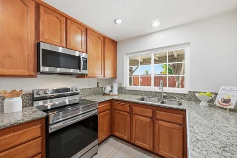 a kitchen with stainless steel appliances granite countertop a sink stove and microwave