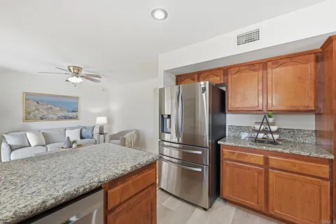 a kitchen with stainless steel appliances granite countertop a sink refrigerator and cabinets
