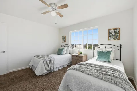 a bedroom with two beds and a chandelier