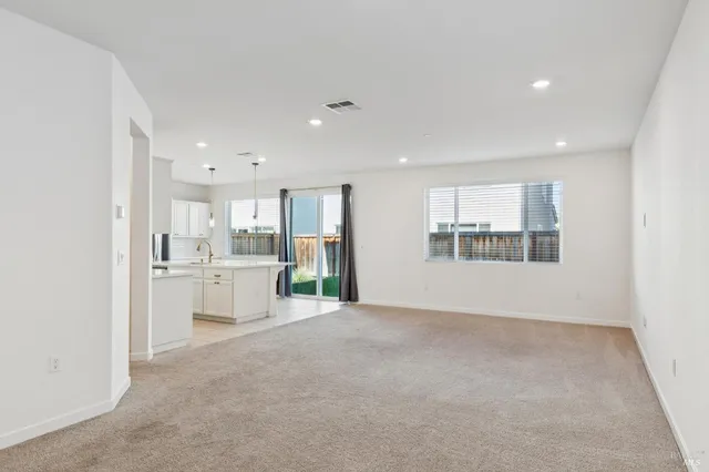 a view of an empty room with a kitchen