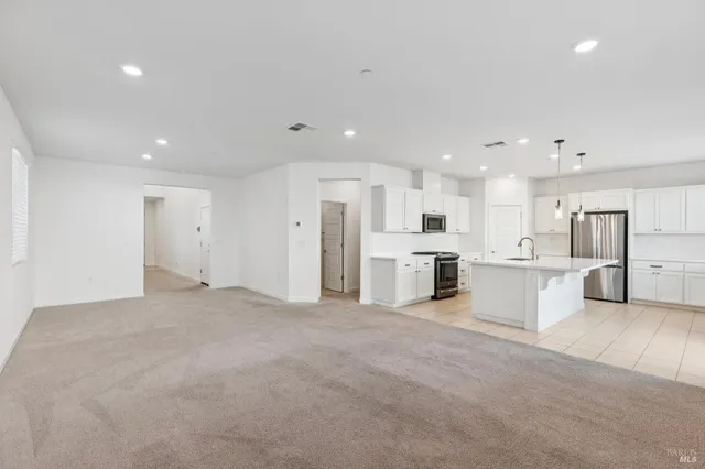 a view of a kitchen with refrigerator and white cabinets