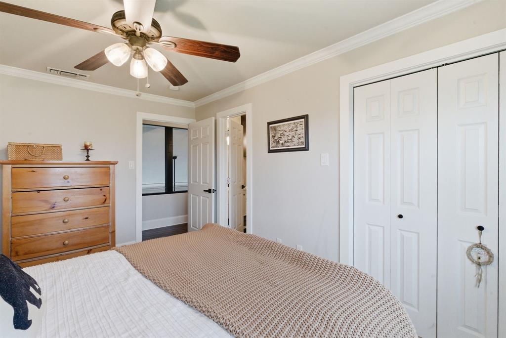5206 Wedgefield Road Granbury, TX 76049 - Photo 22 of 39 a bedroom with a bed and a chandelier