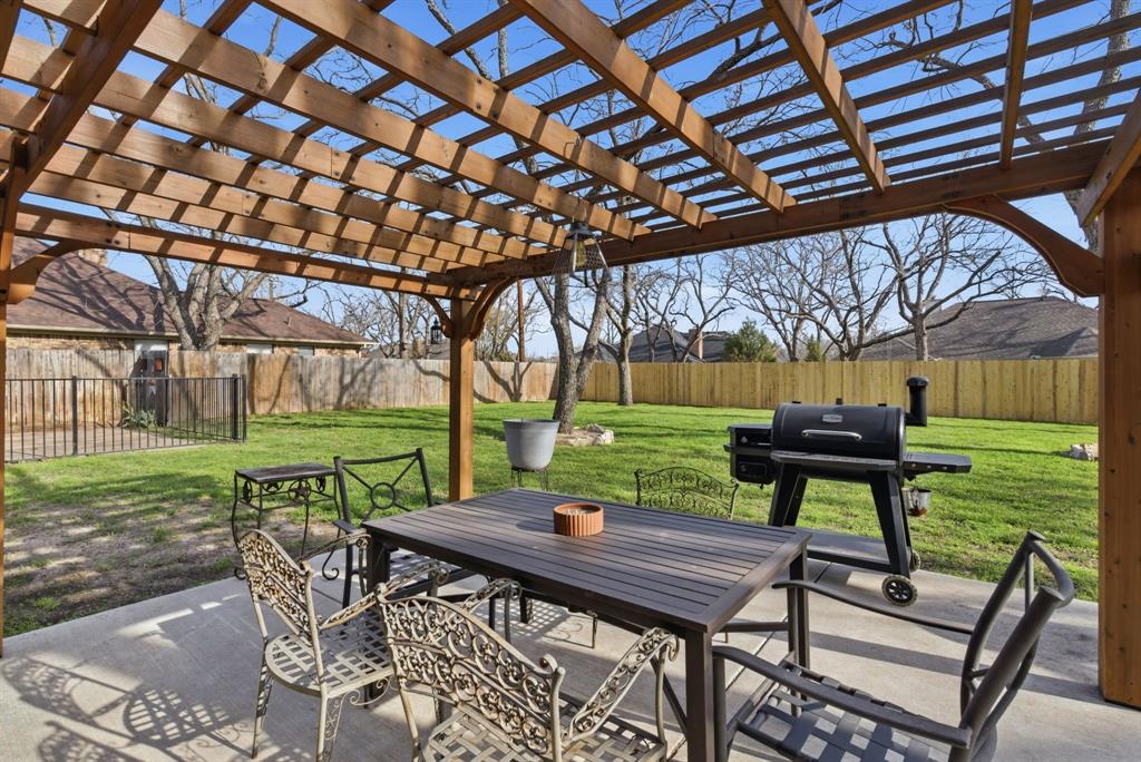 5206 Wedgefield Road Granbury, TX 76049 - Photo 27 of 39 a view of a patio with table and chairs with wooden floor and fence
