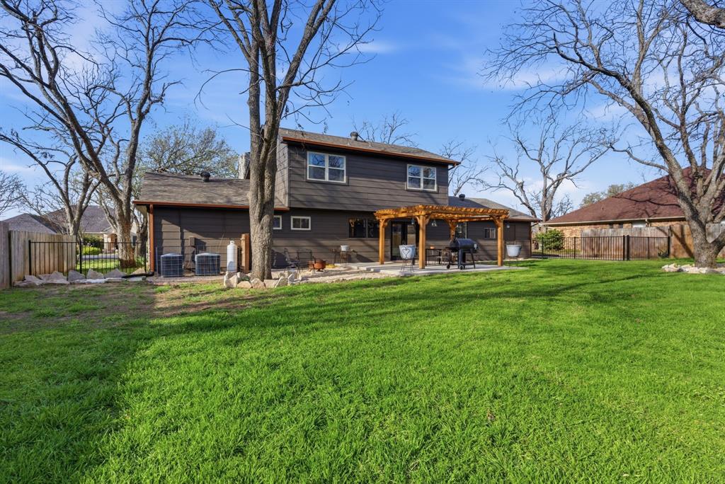 5206 Wedgefield Road Granbury, TX 76049 - Photo 31 of 39 a view of a brick house with a big yard large trees and a big yard