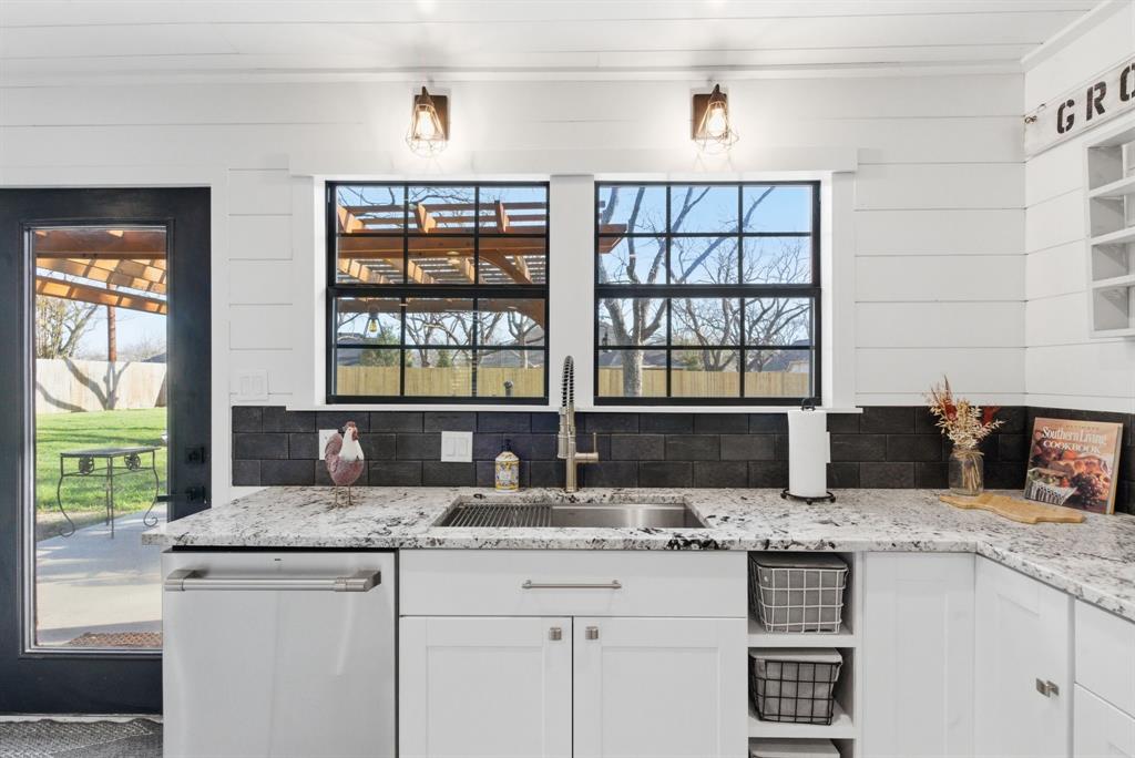 5206 Wedgefield Road Granbury, TX 76049 - Photo 10 of 39 a kitchen with granite countertop a sink and a wooden floor