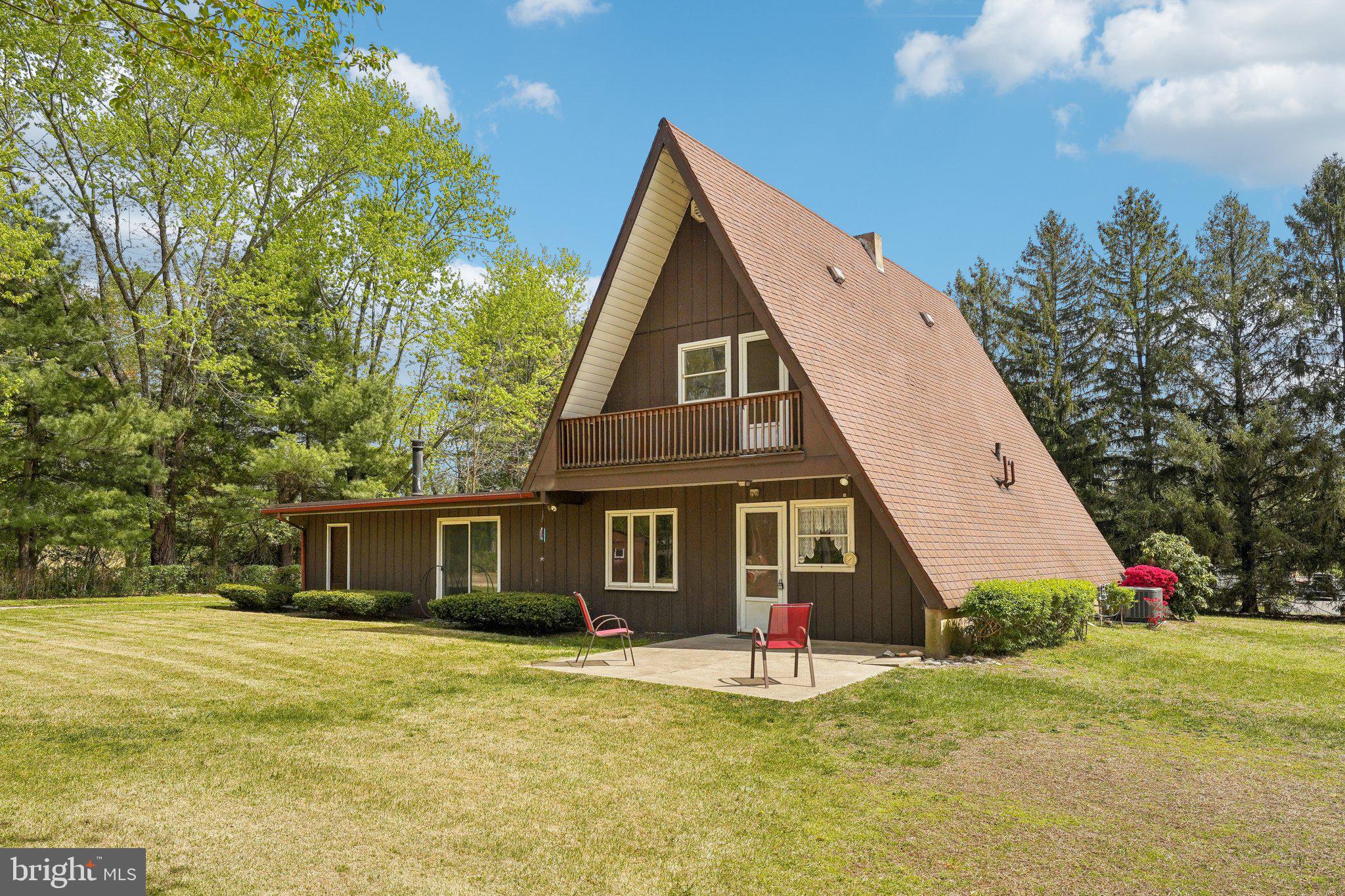 a front view of a house with a yard and trees