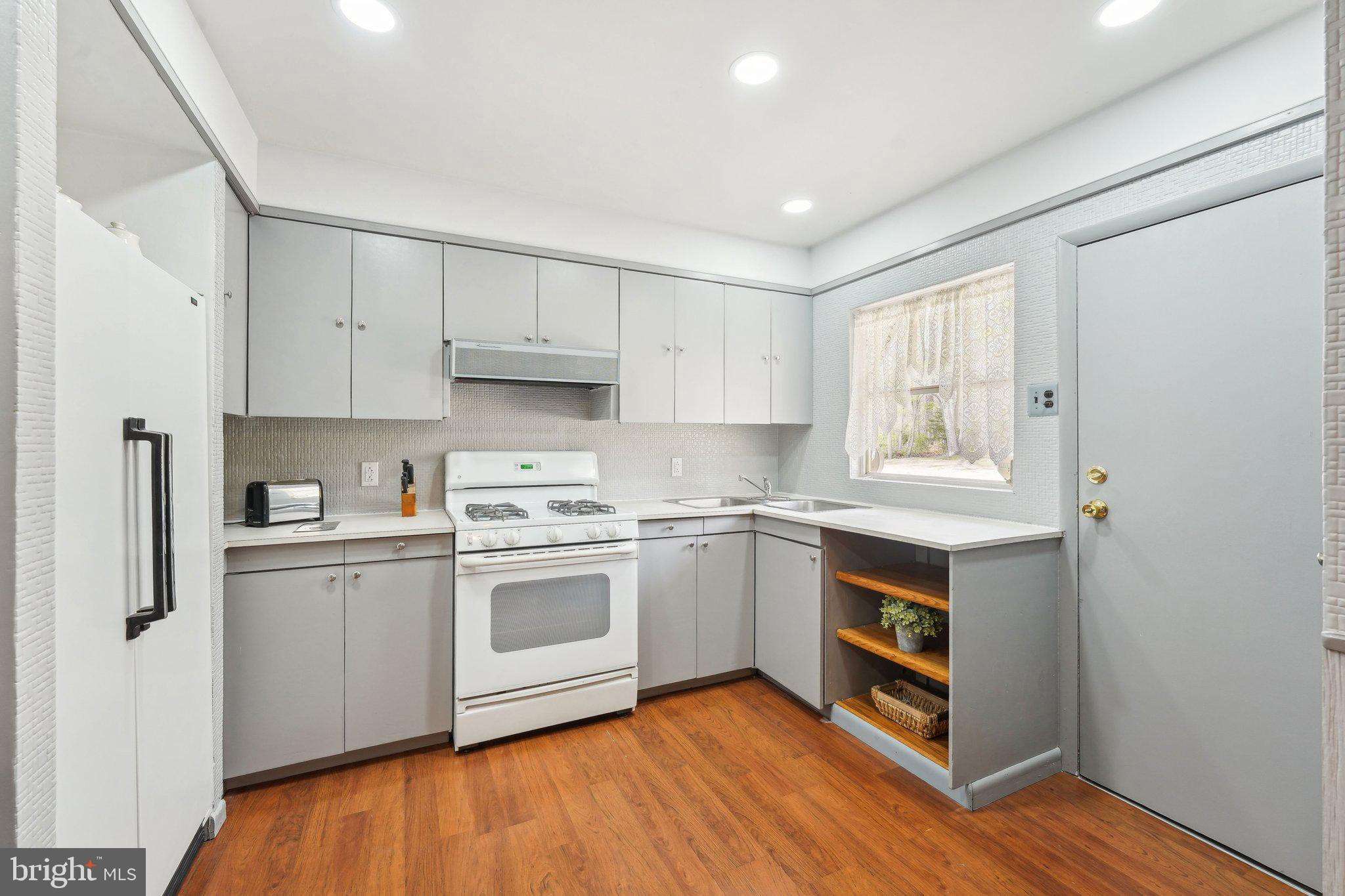 2 Oakview Drive Berlin, NJ 08009 - Photo 15 of 64 a kitchen with stainless steel appliances granite countertop a stove top oven a sink and white cabinets with wooden floor