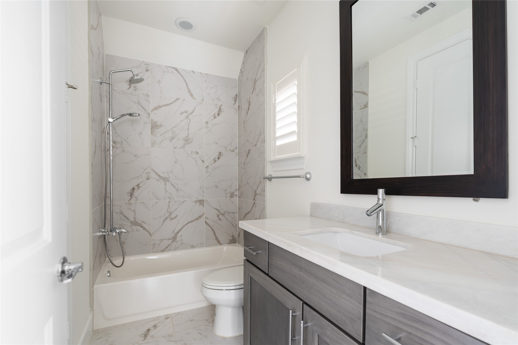 2613 Maxroy Street Houston, TX 77007 - Photo 36 of 43 The ground floor bedroom's en suite bath offers a calm environment with a shower/tub combo with rain shower head, furniture-style vanity, & a dual flush commode.