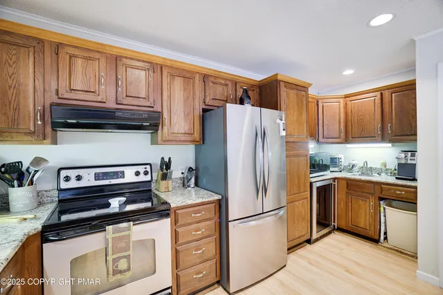 a view of a dining room with furniture a chandelier and large windows