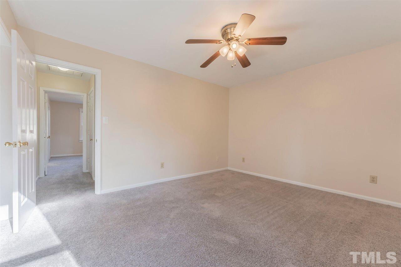 5629 Hamstead Crossing Raleigh, NC 27612 - Photo 20 of 27 an empty room with a chandelier fan and closet area