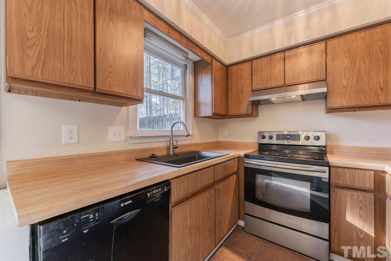5629 Hamstead Crossing Raleigh, NC 27612 - Photo 10 of 27 a kitchen with stainless steel appliances granite countertop a sink stove and microwave