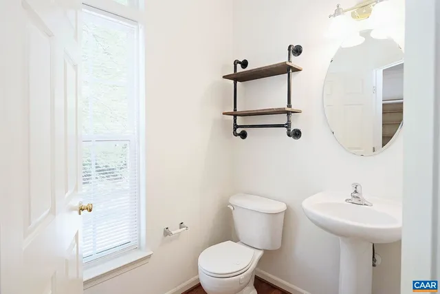 a bathroom with a sink a toilet and a mirror