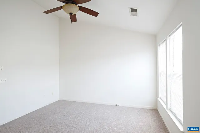 an empty room with a window and a fan