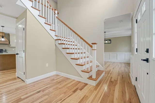 a view of a hallway with wooden floor and staircase