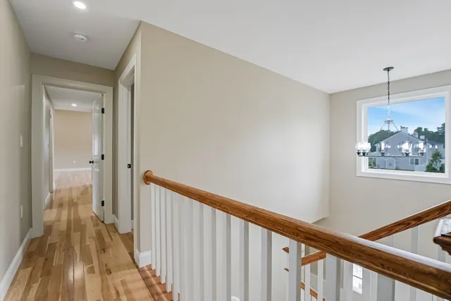 a view of a hallway with wooden floor and staircase
