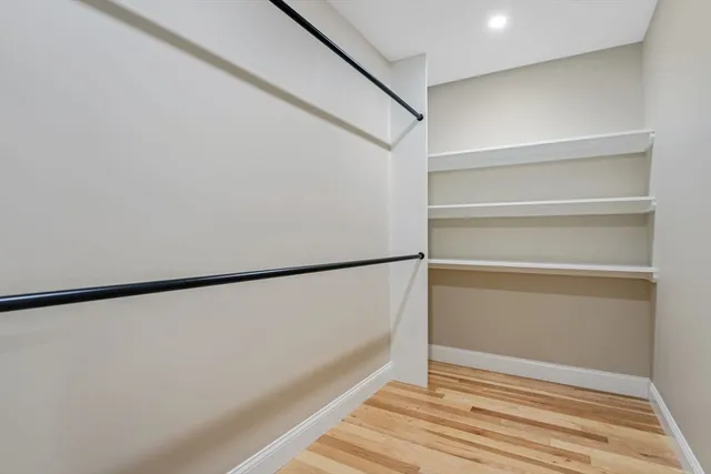 a view of closet with wooden floor