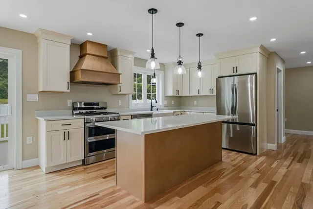 a kitchen with stainless steel appliances a refrigerator a sink and a stove