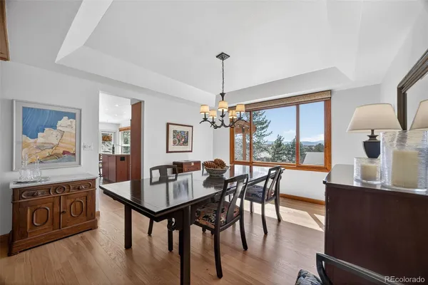 a dining room with furniture a chandelier and wooden floor