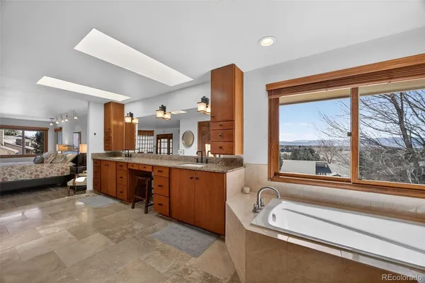 a bathroom with a granite countertop sink and a large mirror