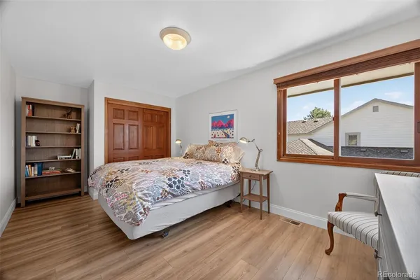 a bedroom with a bed and a dresser next to a window