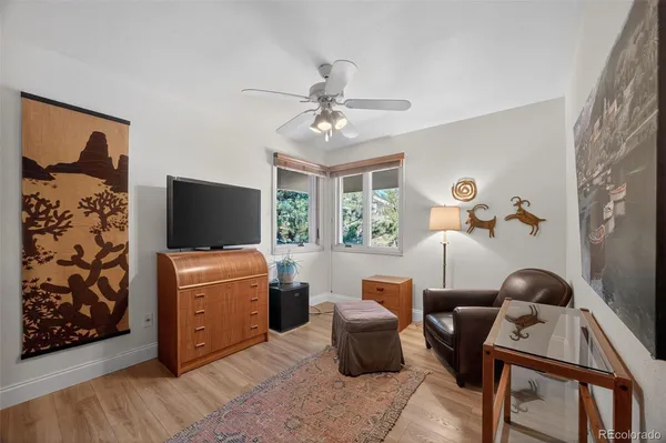 a living room with furniture a flat screen tv and a window
