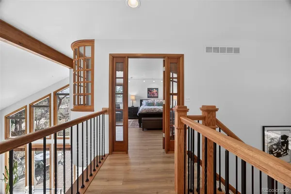 a view of a hallway with wooden floor and furniture