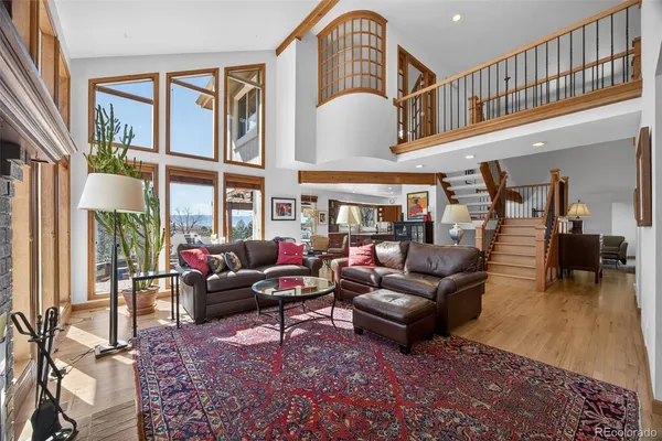 a living room with furniture fireplace and a large window