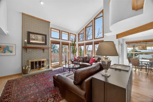 a living room with furniture fireplace and a large window
