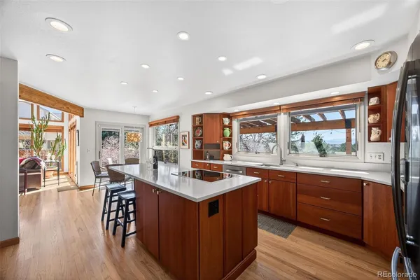 a kitchen with stainless steel appliances granite countertop sink stove and wooden floor