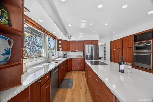 a view of a kitchen with kitchen island a large window a sink and stainless steel appliances