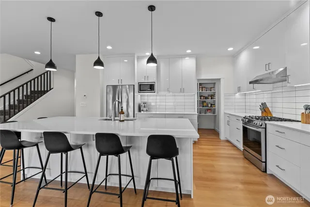 a kitchen with stainless steel appliances kitchen island a large island in the center