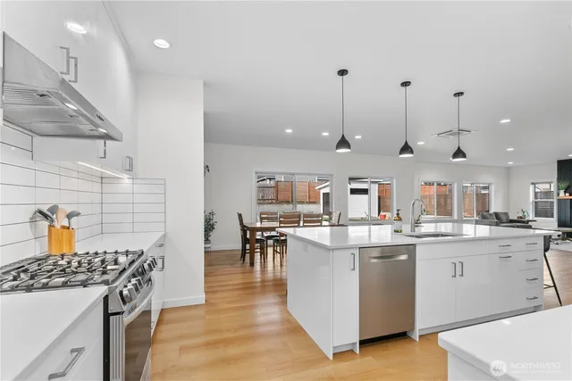 a kitchen with stainless steel appliances granite countertop a sink stove and refrigerator