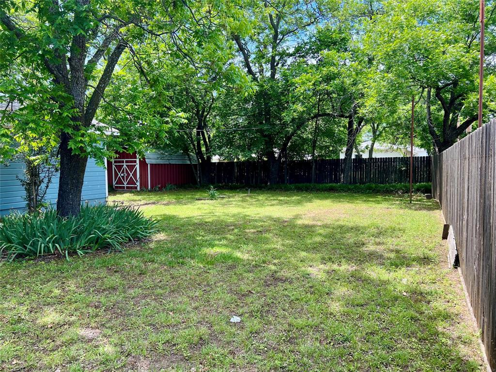200 Dallas Street Nocona, TX 76255 - Photo 13 of 29 a view of a backyard with a large tree
